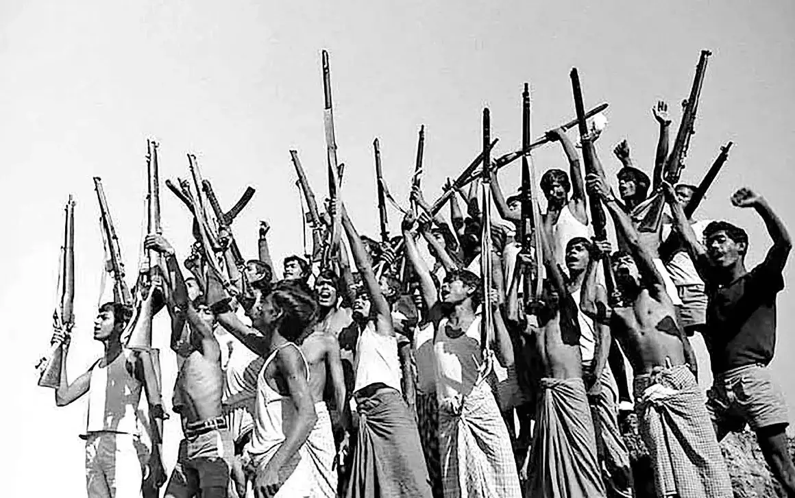 Freedom fighters raise their arms and rifles in celebration of independence in Dohar, Dhaka district, on 16 December 1971.